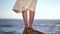 Female feet standing on a stone on the bech.