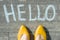 Female feet with text hello written on asphalt