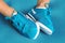 Female feet in turquoise sneakers on turquoise sports mat.