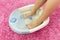 Female feet in a vibrating foot massager. Electric massage foot bath. Relax after work