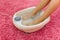 Female feet in a vibrating foot massager home