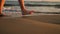 Female feet walking barefoot on sea shore.