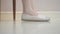 Female feet in white shoes shaking on white floor. foot tapping concept.