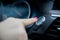 Female finger presses start stop engine button on a car dashboard. close-up, soft focus, in the background the dashboard