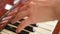 Female fingers playing keys on retro piano keyboard. Shallow depth of field. Focus on hands