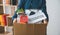 Female firm employee leaving the office with cardboard boxes containing office supplies and personal items after quitting to find