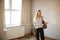 Female First Time Buyer Looking At House Survey In Room To Be Renovated