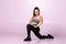 female fit trainer stretching her leg and get ready for workout on pink background, fitness woman stretch to cool down after train