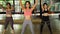 Female fitness women having a Latin dancing class together in gym studio. Group of young sportive women doing putting