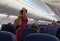 female flight attendant shows passengers how to wear oxygen masks