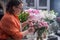 female florist artfully prepares gorgeous bouquet of spring flowers, working at her flower store