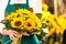 Female florist holding bouquet of sunflowers