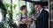 Female florist talking to male customer holding bunch of flowers in store