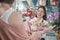 Female florist worker delivers fresh floras to customer in flower shop.