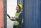 Female foreman checking the number on containers box door with a laptop at Cargo container shipping