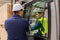 Female forklift driver talking with manager in warehouse, order picking. Warehouse worker preparing products for