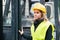 Female forklift truck driver outside a warehouse.