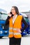 Female forwarder in front of trucks on a depot