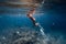 Female free diver swim with jellyfish in blue ocean. Jellyfish in blue sea and freediver girl