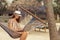 Female freelancer working while in a hammock on the beach