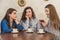 Female friends having a coffee together. Three women at cafe drinking, talking, laughing and enjoying their time