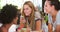 Female Friends Making Breakfast Whilst Checking Mobile Phone