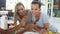 Female Friends Making Breakfast Whilst Checking Mobile Phone