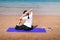 Female friends practicing yoga on the beach