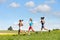 Female friends running downhill sunny meadow