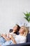 Female friendship - young beautiful women drinking coffee and dreaming about something in cozy living room at home, copy space