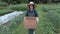 Female gardener carry box in the garden