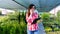 Female gardener or florist talking on phone, holding digital tablet, in garden center or greenhouse. growing and caring