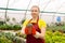 Female gardener in a greenhouse holds a pot with indoor succulent