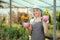 Female gardener holding flower pots in a garden