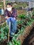 Female gardener in protective mask working in vegetable garden