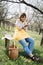 Female gardener resting on wooden bench in orchard