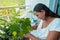 Female gardener sits on a balcony between the plants