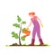 Female gardener waters a tree sapling from a watering can