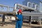 Female gas field operator inspects compressor site