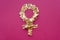 Female gender sign on pink background. Venus sign made from golden sparkles. Feminism, girl power concept. Top view