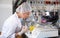 Female geneticist working in laboratory, injecting additives into apple during experiments with genetically modified