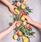 Female girls hands holding seasonal organic fruits from garden: apples, pears, peaches, plums with leaves , top view. Flat lay.