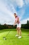 Female golf player on course doing golf swing