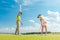 Female golf player ready to hit the ball under the instruction of a golf teacher