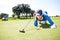 Female golfer blowing her ball on putting green