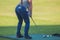 Female golfer girl player practicing and training golf swing on driving range practice, woman playing on golf course, golf ball at