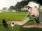 Female Golfer Placing Ball On Tee