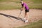 Female golfer on a sand trap