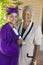 Female Graduate With Grandmother Smiling