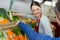 female greengrocer selling vegetables to customer